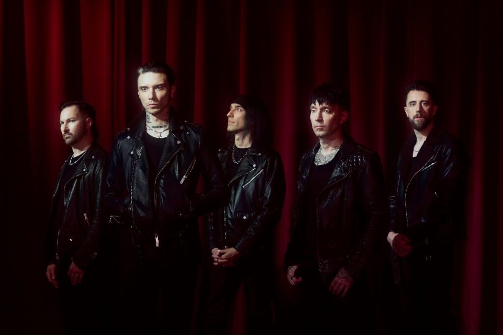 Black Veil Brides standing in a row wearing black leather jackets against a deep red curtain backdrop.