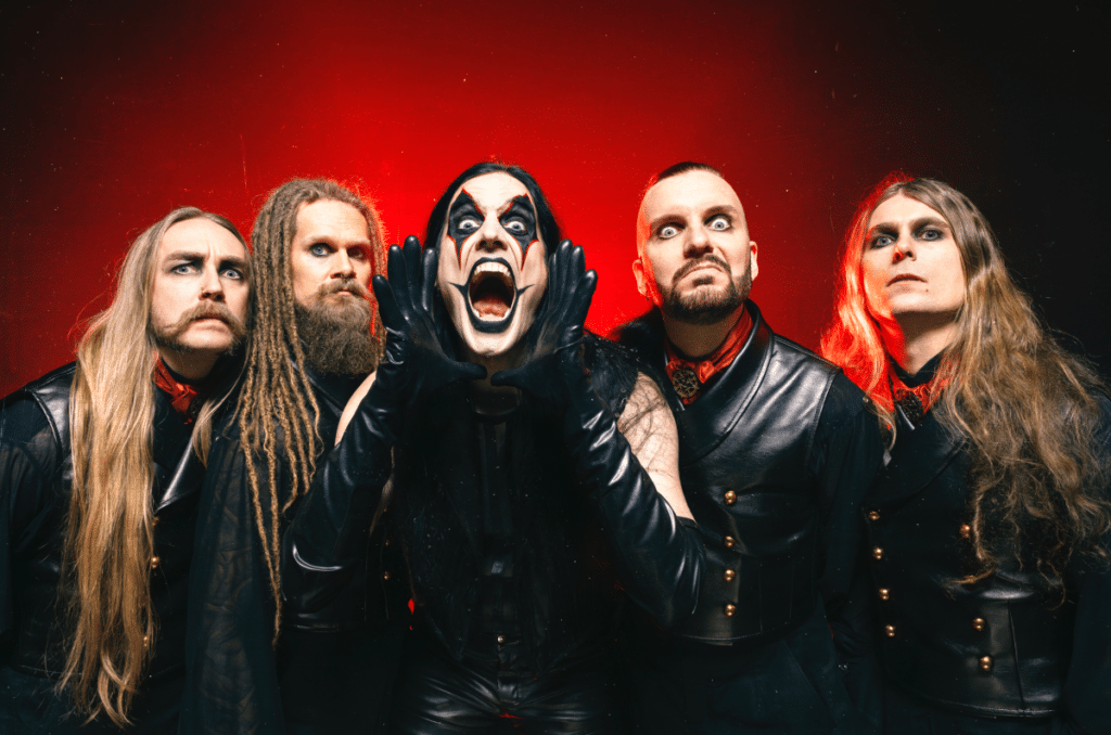 Avatar band members in full stage attire and corpse paint, led by vocalist Johannes Eckerström screaming against a red-lit background during the Don’t Go In The Forest era.